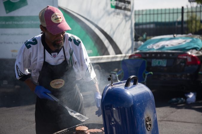 Myron Artis has been manning the grill for 15 years at the Morris family tailgate. (Emily Cohen for WHYY)