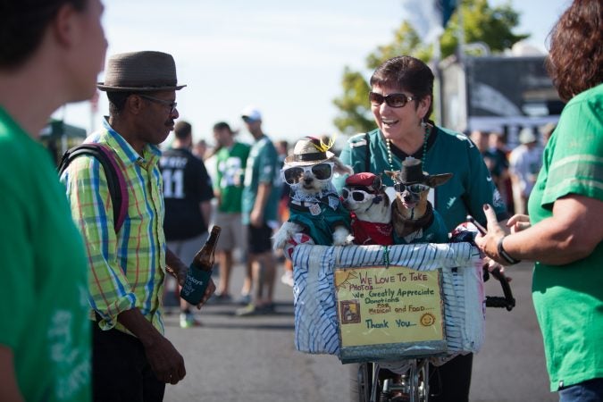 Renie McDevitt, of Glen Mills, poses with the Philadelphia famous pups of Anthony Smith. (Emily Cohen for WHYY)