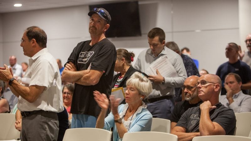 Jim Dougherty (second from left) waits in line for his turn to talk at the township meeting. (Emily Cohen for WHYY)