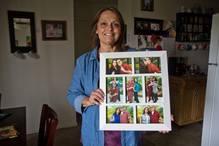 Joanne Schilk-Bierman holds framed photos from visits to her oldest brother Tom Schilk, who’s serving a life sentence in prison. (Kimberly Paynter/WHYY)