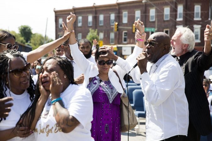 Bishop Benjamin Peterson Jr. places his hands on churchgoer Donna Griffin on Sept. 1, 2019. (Rachel Wisniewski for WHYY)