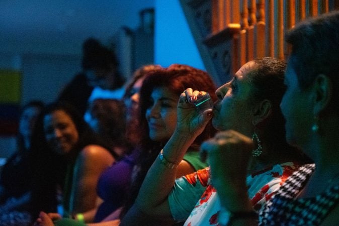 Mariela Bedoya takes a shot of tequilla during the vijoteca in Oxford Circle on Saturday, September 14, 2019. (Kriston Jae Bethell for WHYY)