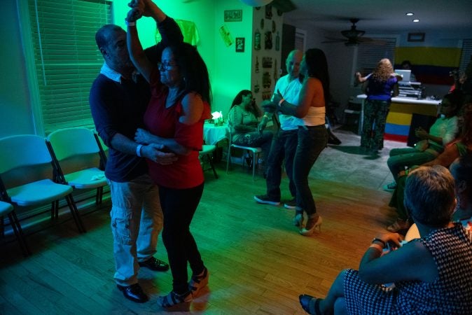 Guests dance in a viejoteca held in an Oxford Circle home on Sunday, September 15, 2019. (Kriston Jae Bethel for WHYY)