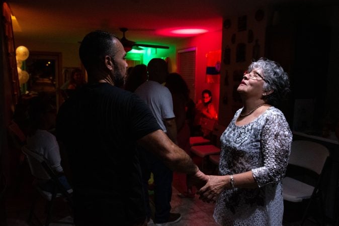 Milena Sanchez dances with her son, Einar Victoria, in the kitchen during a viejoteca on Sunday, September 15, 2019. (Kriston Jae Bethel for WHYY)