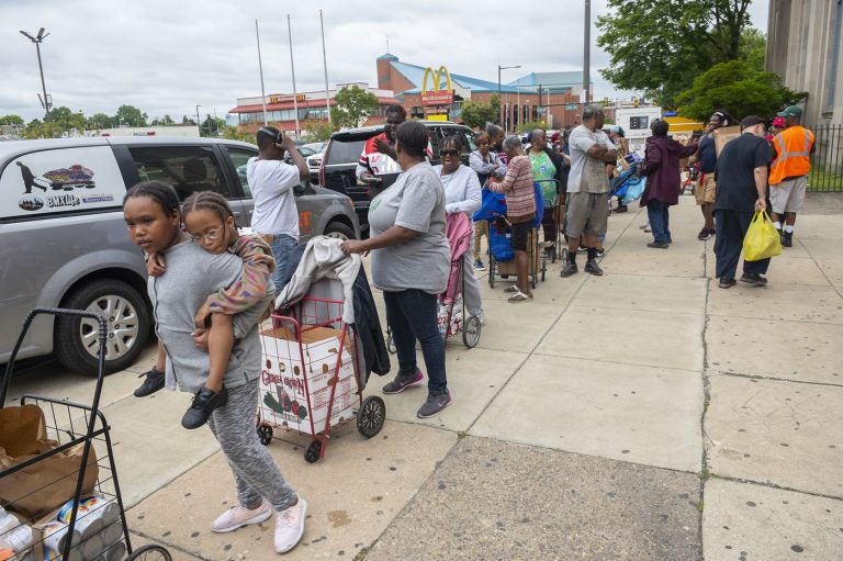 People queue up during a food giveaway at Dobbins High School in North Philadelphia this summer. (Avi Steinhardt/The Philadelphia Inquirer)