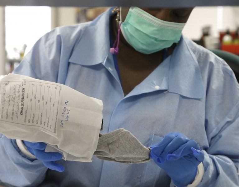 In this April 2, 2015, file photo, a forensic analyst removes a pair of underwear from an evidence bag for testing in a sexual assault case in the biology lab at the Houston Forensic Science Center in Houston, Texas. (Pat Sullivan/AP Photo, File)