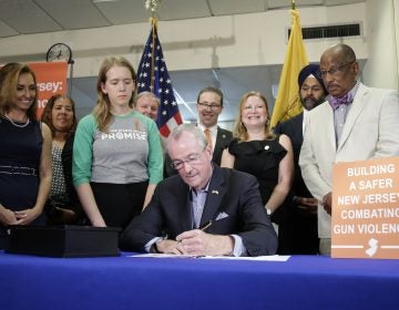 New Jersey Gov. Phil Murphy, center, signs a gun control bill during a ceremony in Berkeley Heights, N.J., Tuesday, July 16, 2019. (AP Photo/Seth Wenig)