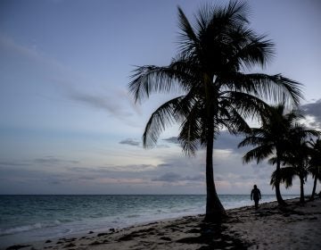 A woman walks along a beach before the arrival of Hurricane Dorian in Freeport, Grand Bahama, Bahamas, Saturday Aug. 31, 2019. Hurricane Dorian is closing in on the northern Bahamas, threatening to batter the normally idyllic islands with fierce winds, pounding waves and torrential rain. (Ramon Espinosa/AP Photo)