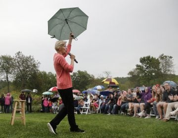 Democratic presidential candidate Sen. Elizabeth Warren, D-Mass., gestures with an umbrella as she speaks at a campaign event, Monday, Sept. 2, 2019, in Hampton Falls, N.H. (AP Photo/Elise Amendola)