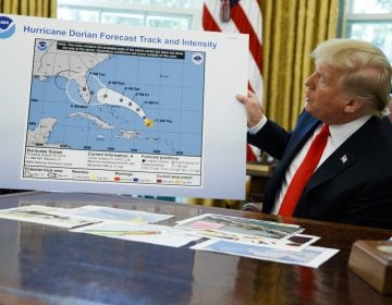 President Donald Trump holds a chart as he talks with reporters after receiving a briefing on Hurricane Dorian in the Oval Office of the White House, Wednesday, Sept. 4, 2019, in Washington. (AP Photo/Evan Vucci)