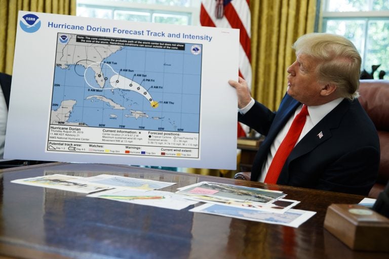 President Donald Trump holds a chart as he talks with reporters after receiving a briefing on Hurricane Dorian in the Oval Office of the White House, Wednesday, Sept. 4, 2019, in Washington. (AP Photo/Evan Vucci)