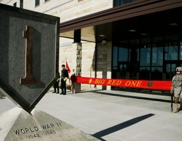 In this Feb. 9, 2015 file photo, an honor guard stands at the entrance before ribbon cutting ceremonies for the new 1st Infantry Division Headquarters at Fort Riley, Kan. Prosecutors say a U.S. Army infantry soldier stationed at Fort Riley shared bomb-making instructions online and also discussed killing activists and bombing a news network. The Justice Department says Monday, Sept. 23, 2019, that private first class Jarrett William Smith was charged with distributing information related to explosives and weapons of mass destruction. (AP Photo/Orlin Wagner File)