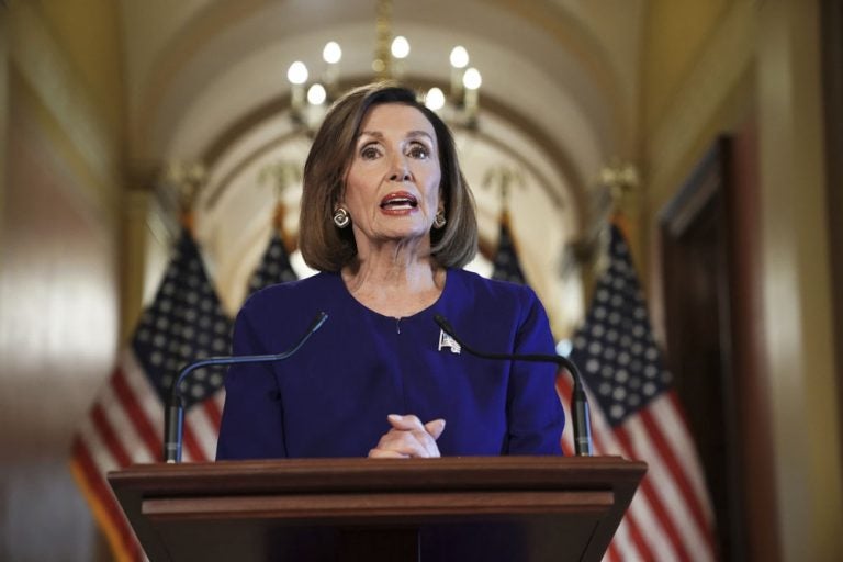 House Speaker Nancy Pelosi stands at a podium