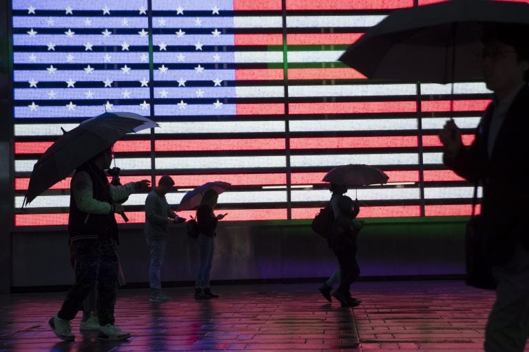 Visitors to New York's Times Square use umbrellas to shield themselves against the rain