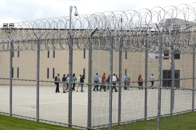 In this June 1, 2018, file photo, people walk on a tour of the West section of the State Correctional Institution at Phoenix in Collegeville, Pa. (AP Photo/Jacqueline Larma, File)