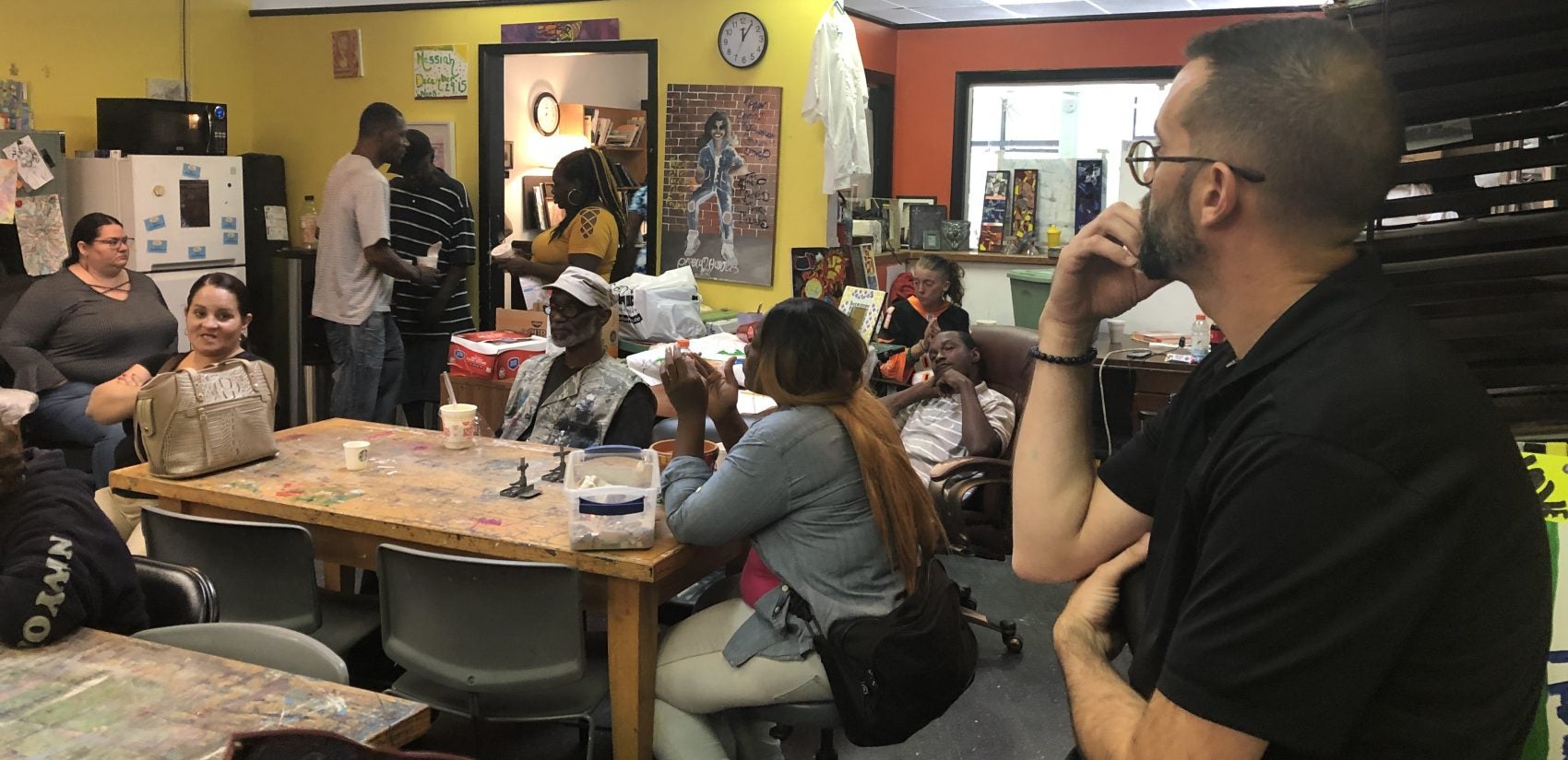 Director Michael Kalmbach (right foreground) presides over the daily check-in session at the arts and therapeutic center. (Cris Barrish/WHYY)