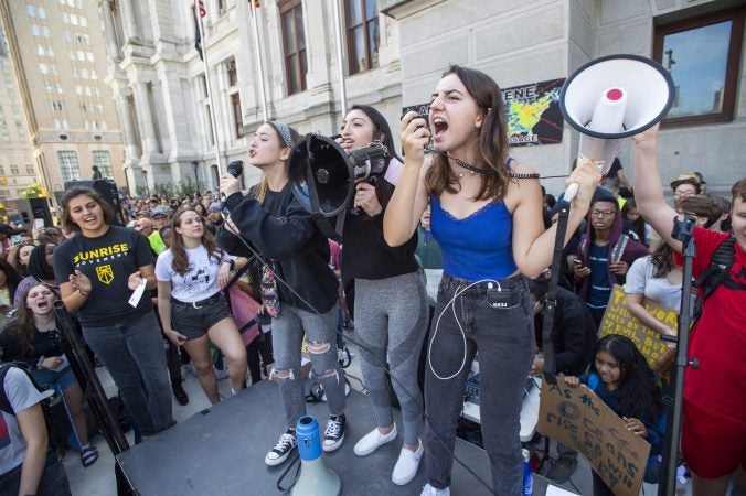 From left, Emily Mooney from Harriton High School, Zenz Mazahreh and Lola Hadgines from the Academy at Palumbo lead the crowd in a cheer. (Jonathan Wilson for WHYY)