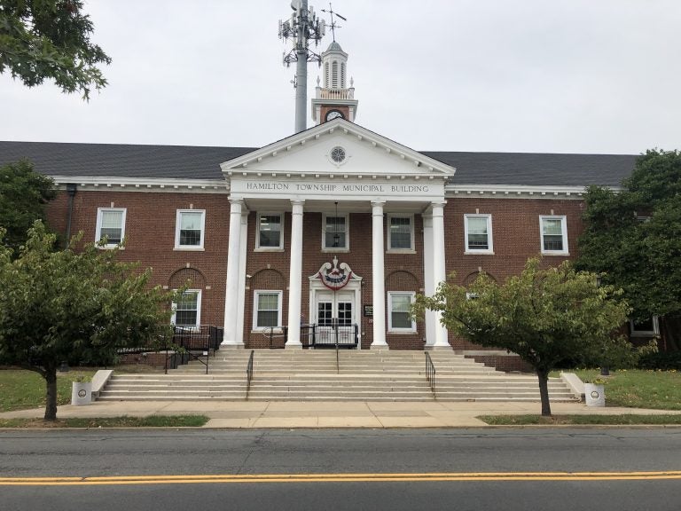 A large red-brick building with white columns at the front is visible.