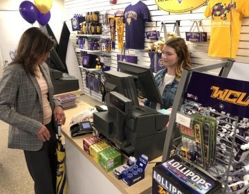 Monica Zimmerman, executive director of West Chester University’s Entrepreneurial Leadership Center, purchases a travel mug from The Ram Shop at the edge of campus. WCU student Madeline Berger rings up the transaction. (P. Kenneth Burns/WHYY)