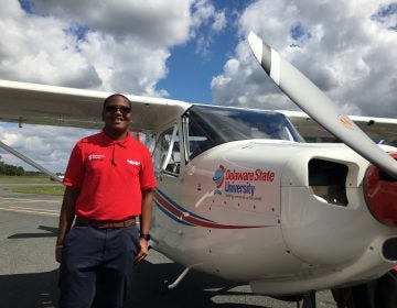Sophomore Christian Black stands next to a new Vulcanair plane that he’ll be training on at Delaware State University. (Mark Eichmann/WHYY)
