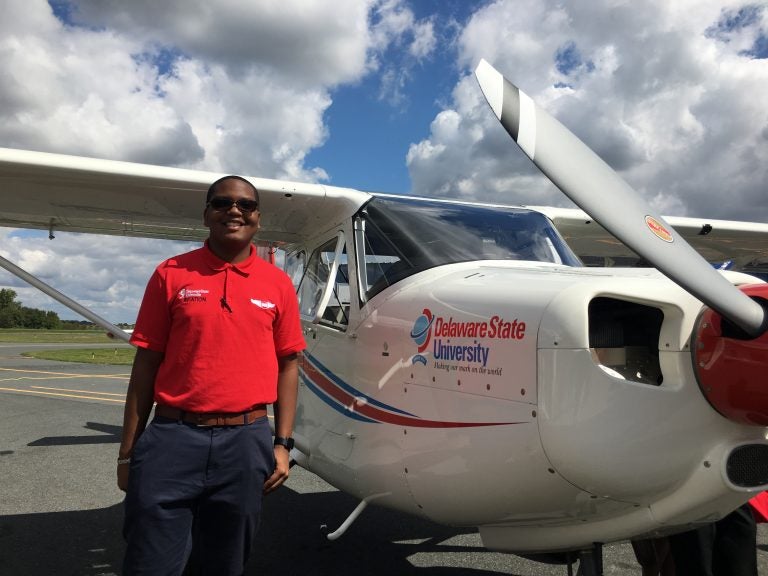 Sophomore Christian Black stands next to a new Vulcanair plane that he’ll be training on at Delaware State University. (Mark Eichmann/WHYY)