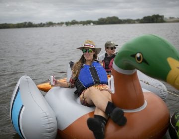 Erica Baugh of Upstream Alliance floats on the Delaware River in Pyne  Poynt Park in Camden, N.J. (Miguel Martinez for WHYY)