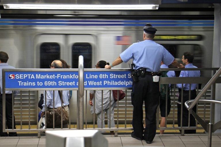 A transit police officer keeps watch on the Market-Frankford line. (Emma Lee/WHYY)