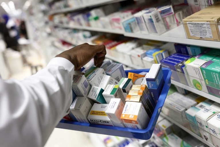 A pharmacist collects packets of boxed medication from the shelves of a pharmacy in London, U.K. A proposal announced by House Speaker Nancy Pelosi Thursday would allow the government to directly negotiate the price of 250 U.S. drugs, using what the drugs cost in Australia, Canada, France, Germany, Japan, and the United Kingdom as a baseline. (Bloomberg via Getty Images)