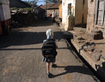 A child leaves for school in a village in India. Last November, the Indian government announced new rules limiting the weight of school bags depending on a child's age. But the rules are not always enforced. (Punit Paranjpe /AFP/Getty Images)