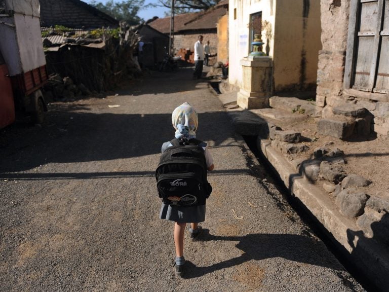 A child leaves for school in a village in India. Last November, the Indian government announced new rules limiting the weight of school bags depending on a child's age. But the rules are not always enforced. (Punit Paranjpe /AFP/Getty Images)