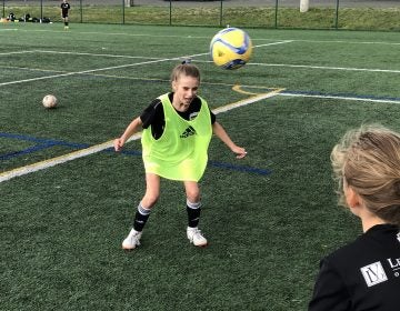 Eleven-year-old Ella Koehler, of Seattle United soccer club, heads the ball at a practice on the University of Washington campus. It's the first year she and her teammates of the same age can use the technique. A 2015 rule by the U.S. Soccer Federation banned heading for kids ages 10 years old and younger. (Tom Goldman/NPR)