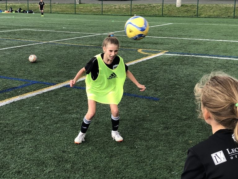 Eleven-year-old Ella Koehler, of Seattle United soccer club, heads the ball at a practice on the University of Washington campus. It's the first year she and her teammates of the same age can use the technique. A 2015 rule by the U.S. Soccer Federation banned heading for kids ages 10 years old and younger. (Tom Goldman/NPR)
