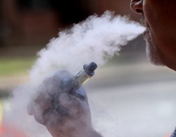 In this Aug. 28, 2019 photo a man exhales while using an e-cigarette Wednesday, in Portland, Maine. (AP Photo/Robert F. Bukaty)