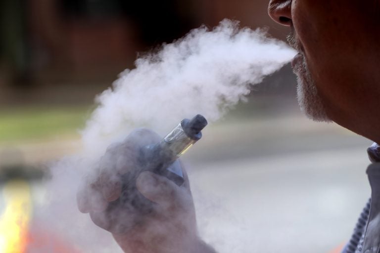 In this Aug. 28, 2019 photo a man exhales while using an e-cigarette Wednesday, in Portland, Maine. (AP Photo/Robert F. Bukaty)