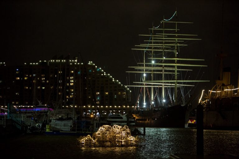 Stephen Talasnik's Endurance sits illuminated in the Delaware River boat basin ready for the opening of the FLOW exhibition. FLOW is a sculpture exhibit on the Delaware River in partnership with Philadelphia Sculptors and the Independence Seaport Museum. (Emily Cohen for WHYY)