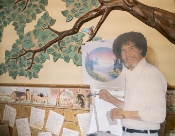 A life size cut out of Bob Ross stands up against the wall where the historical tree of the Franklin Park Arts Center is painted. Bob Ross Inc. is located in Herndon, Va., which is only 27 miles from the exhibit. According to managing director, Elizabeth Bracey, the exhibit was intentionally kept close to headquarters. (Mhari Shaw/NPR)