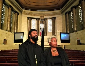 Bradford Young and Elissa Blount Moorhead stand in the Girard College chapel with their video installation, 'Back and Song.' (Peter Crimmins/WHYY)