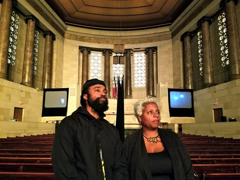 Bradford Young and Elissa Blount Moorhead stand in the Girard College chapel with their video installation, 'Back and Song.' (Peter Crimmins/WHYY)