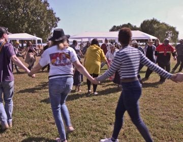 Dancers from the Nanticoke Lenni-Lenape tribe join hands with spectators at the 2019 Indigenous Peoples’ Day celebration at Penn Treaty Park in Philadelphia. (Kimberly Paynter/WHYY)