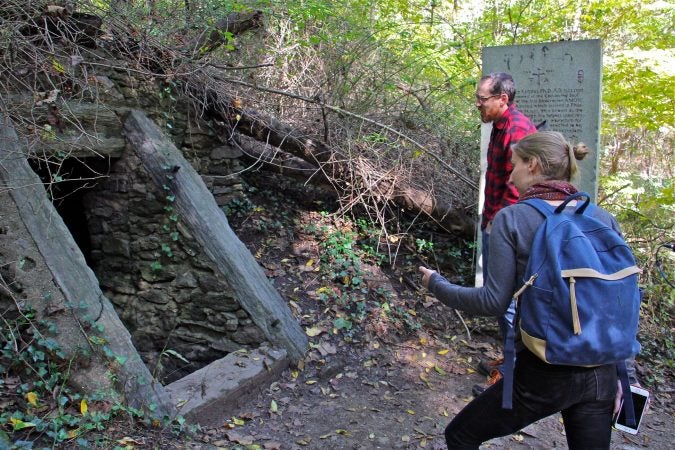 Shai Ben-Yaacov and Kelsey Hanson approach the mouth of the Cave of Kelpius. (Emma Lee/WHYY)