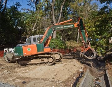 An excavator removes concrete pipe as part of a plan to restore a waterway at Conklin Recreation Center. (Kimberly Paynter/WHYY)