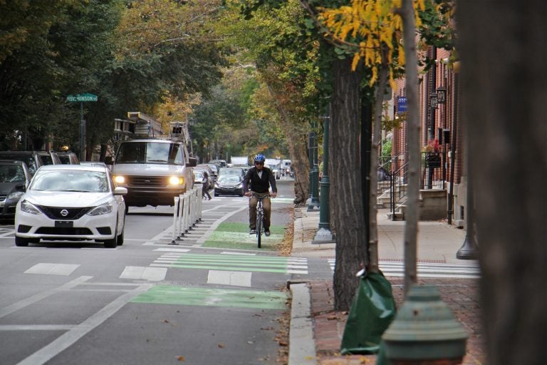 Delineator posts protect a cyclist at Pine and 9th streets. (Emma Lee/WHYY)