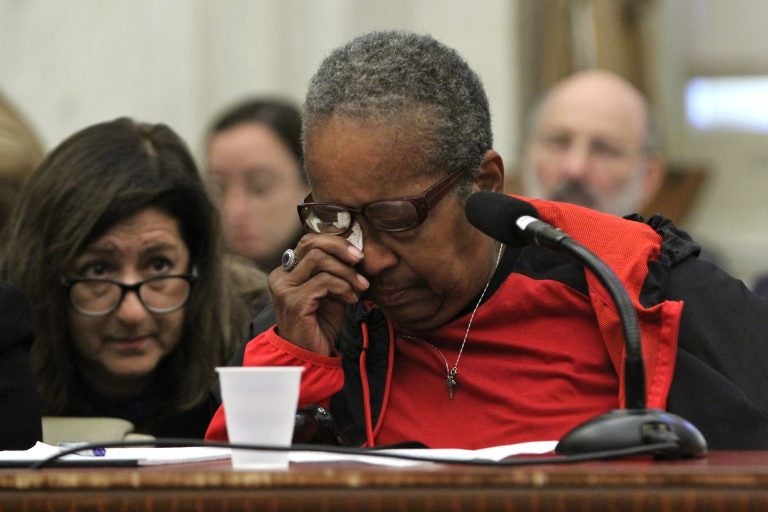 Belinda Thomspson, 69, wipes away tears as she tells how her brother tried to evict her from her mother's house. She spoke during a hearing on a City Council bill that would guarantee legal counsel for those facing eviction. (Emma Lee/WHYY)