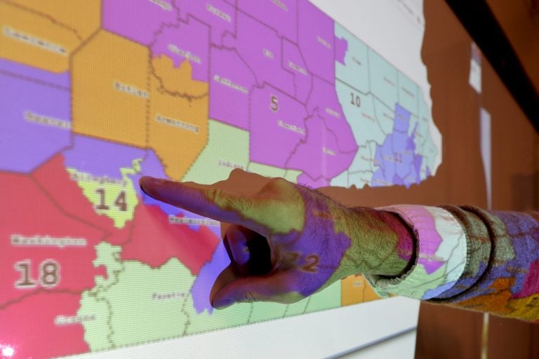 William Marx points out one of the districts that crossed four counties as an image of the old congressional districts of Pennsylvania are projected on a wall in the classroom where he teaches civics in Pittsburgh on Friday, Nov. 16, 2018. Marx was a plaintiff in the Pennsylvania lawsuit that successfully challenged the Republican-drawn congressional maps. Marx said he believes the new district boundaries resulted in 