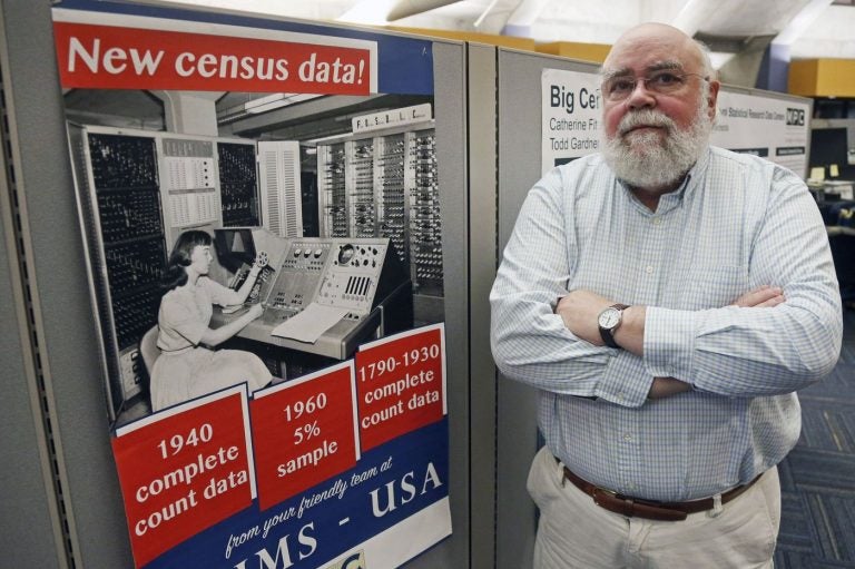 Steven Ruggles, director of the Institute for Social Research and Data Innovation at the University of Minnesota, poses next to a Census Bureau poster. (Jim Mone/AP Photo)