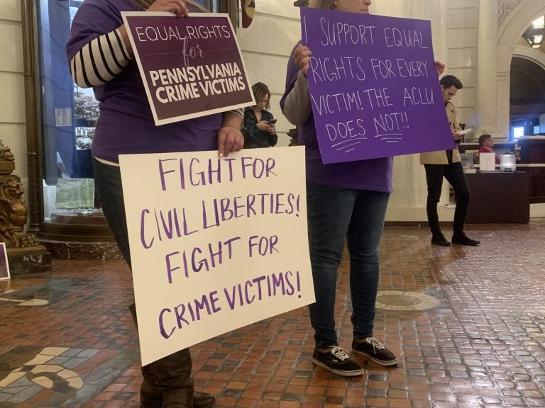 File photo: Supporters of Marsy's Law held signs in protest during the ACLU's press conference announcing its lawsuit. (Katie Meyer/WHYY)