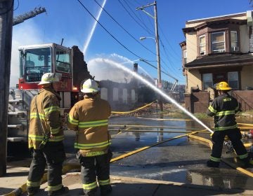 Firefighters attacking the flames of a fire in an auto shop at 59th and Irving streets in West Philly. (Kimberly Paynter/WHYY)