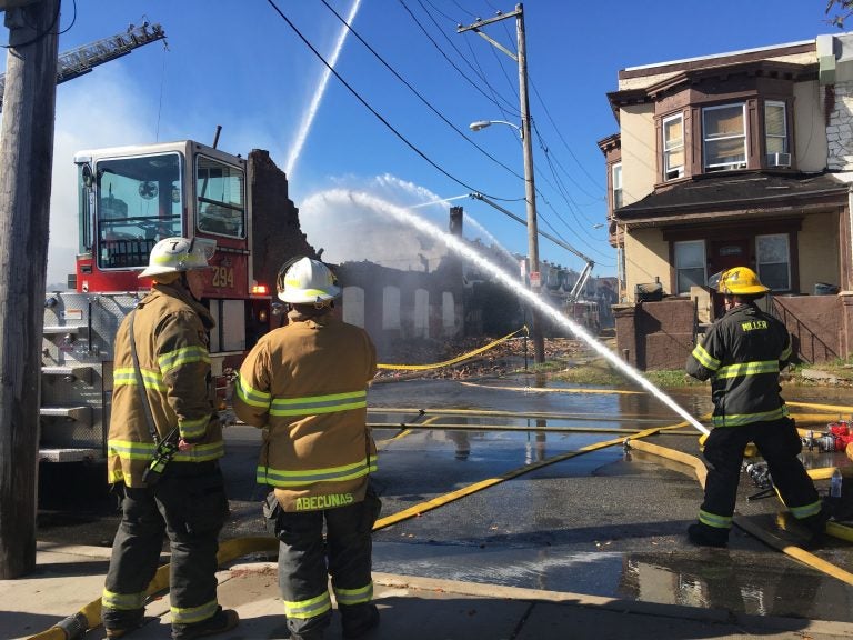 Firefighters attacking the flames of a fire in an auto shop at 59th and Irving streets in West Philly. (Kimberly Paynter/WHYY)