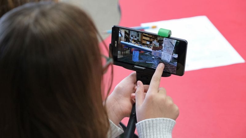 Aalyah Bleyer, 9, works with a tornado simulation augmented reality program on a smartphone Sept. 26, 2019, at Whitfield Elementary School in Spring Township, Pennsylvania. (Matt Smith for Keystone Crossroads)