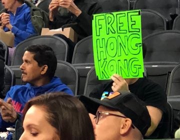 Sam Wachs holds a sign that reads 'Free Hong Kong' at the Sixers pre-season game. (Courtesy of Sam Wachs)